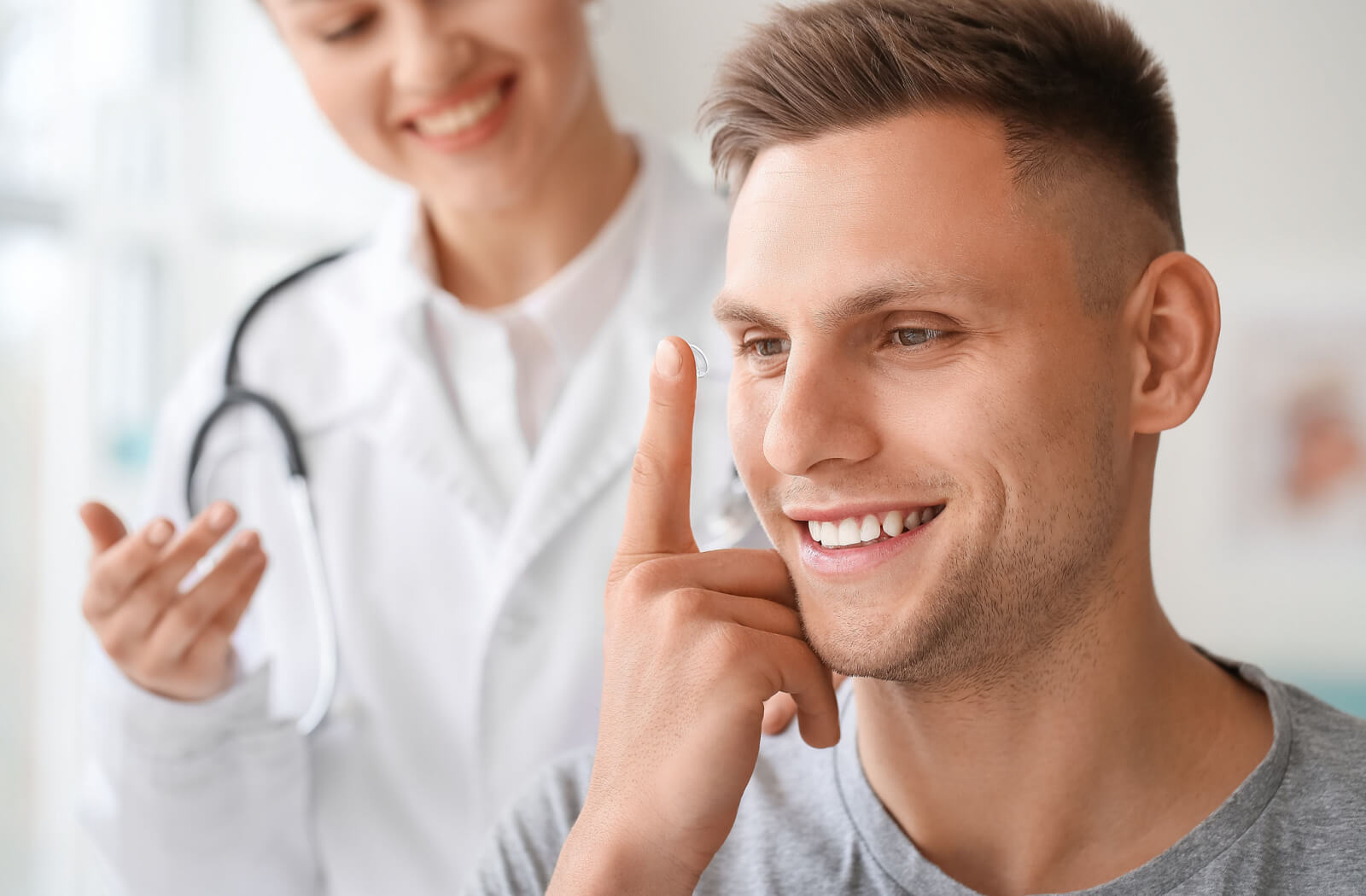 Young man putting in new contact lenses as a replacement for his expired contact lenses.