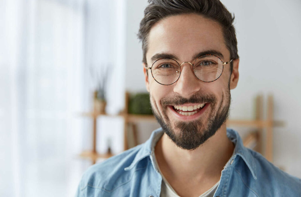 A man smiling while wearing a pair of properly fitting eyeglasses
