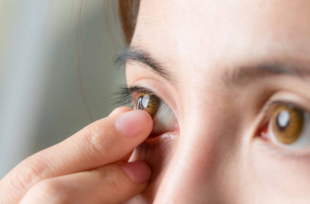 Close-up shot of young woman removing her contact lens before bed time