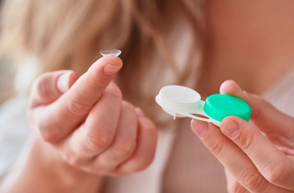 Close up of hands holding a contact lens and case.