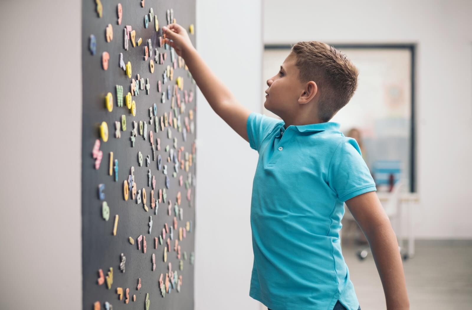 A child practicing hand-eye coordination by placing magnets on a board